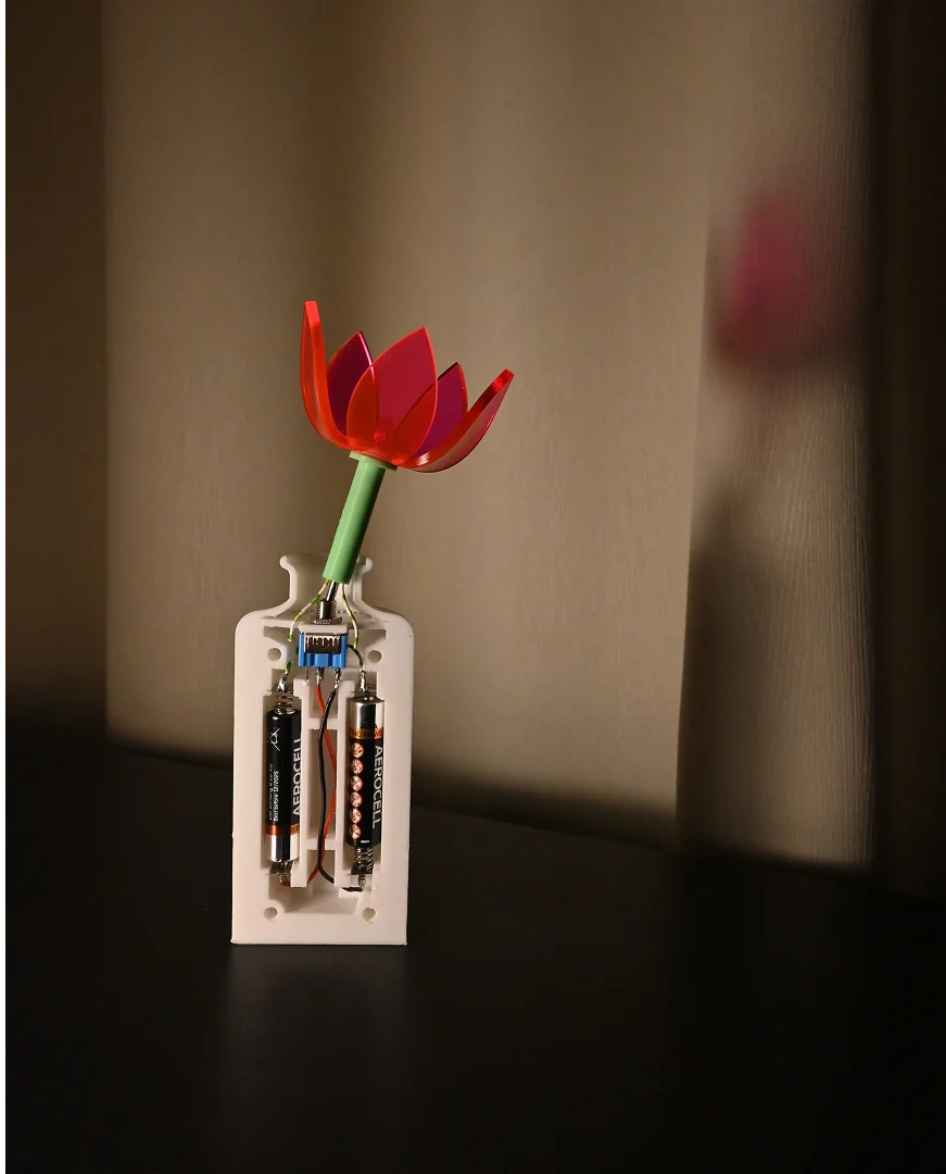 Vart liigutades sisselülitatav lamp. Modelleeritud Fusion 360-s, 3D-prinditud vaasiosa ja vars, laseriga lõigatud pleksiklaasist õis.