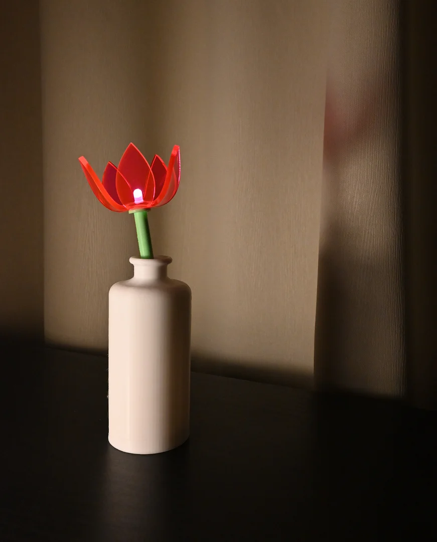 Vart liigutades sisselülitatav lamp. Modelleeritud Fusion 360-s, 3D-prinditud vaasiosa ja vars, laseriga lõigatud pleksiklaasist õis.